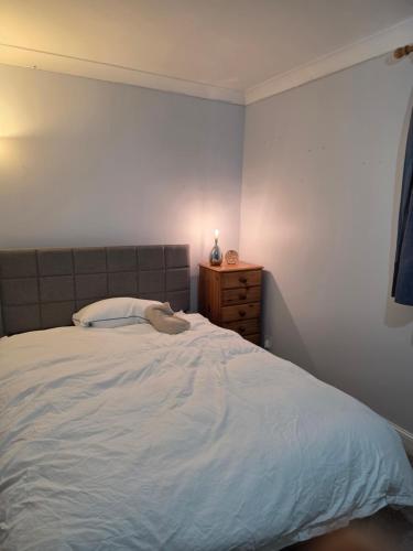a bedroom with a bed and a wooden dresser at Colchester chill x1 in Hythe