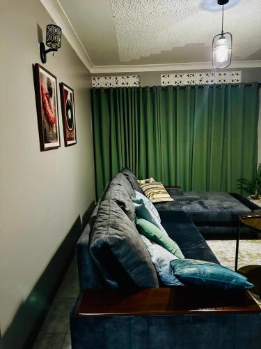 a living room with a couch and green curtains at Kylo cozy calm in Kampala