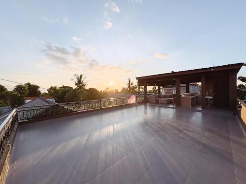 a large balcony with a view of the sunset at MeyGun House in Lovina