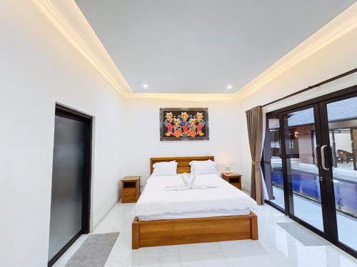 a bedroom with a bed and a large window at MeyGun House in Lovina