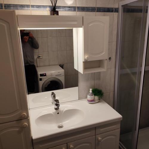 a man taking a picture of a sink in a bathroom at Loft apartment in the heart of Hamar in Hamar