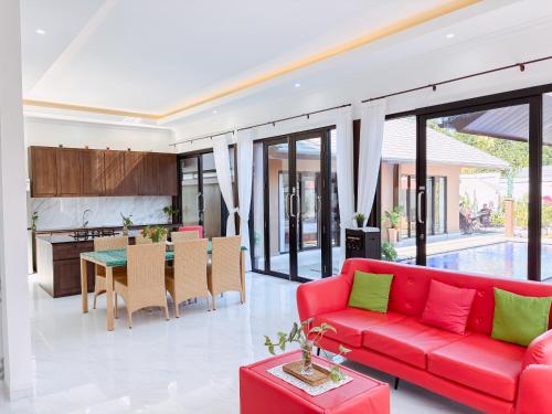 a living room with a red couch and a table at MeyGun House in Lovina