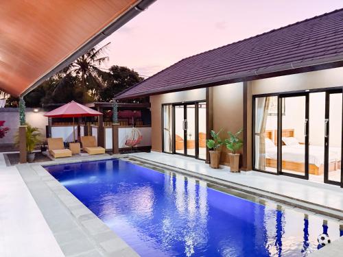 a swimming pool in front of a house at MeyGun House in Lovina