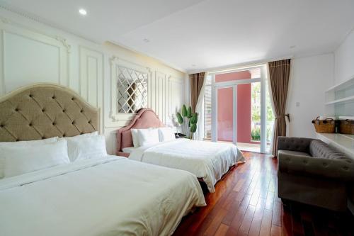 a hotel room with two beds and a couch at Casa de LYN Nha Trang in Nha Trang