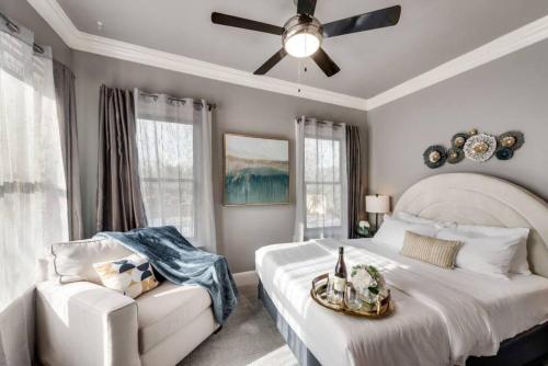 a bedroom with a bed and a chair and a ceiling fan at Swiss Avenue Luxury 1br Condo Historic Dallas in Dallas