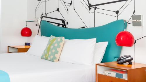 a bedroom with a bed and two red lamps at The Vagabond Hotel Miami in Miami