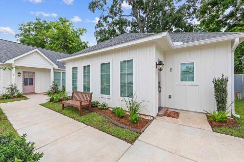 a white house with a bench in the front yard at New Extra Innings Cottage - Studio - Sports Complex in Youngsville