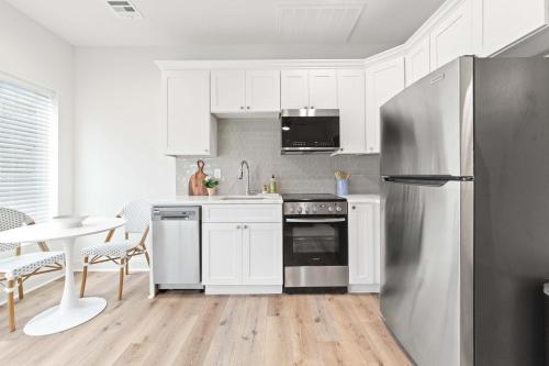 a kitchen with white cabinets and a stainless steel refrigerator at New Extra Innings Cottage - Studio - Sports Complex in Youngsville