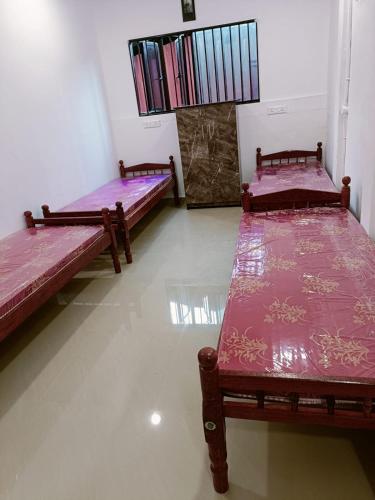 a room with two beds with purple sheets on them at Kerala ladies hostel in Ernakulam