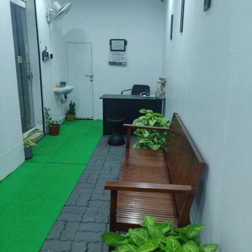 an office with a bench and a desk with plants at Kerala ladies hostel in Ernakulam