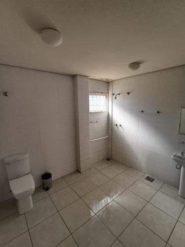 an empty bathroom with a toilet and a sink at Sallimas Hotel in Sorocaba