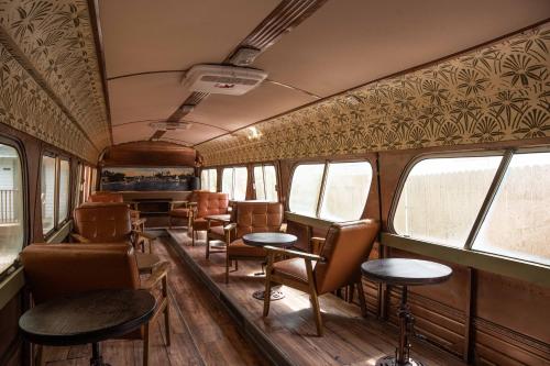 an old train car with chairs and tables and windows at Miami River Inn by Renzzi in Miami