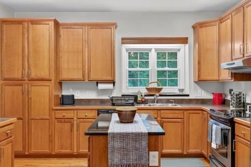 a kitchen with wooden cabinets and a sink at Family Screened Porch with Swing Fire Pit Grill and Deck in Luray