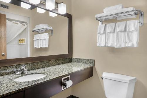 a bathroom with a sink and a mirror and a toilet at BEST WESTERN PLUS Saint John Hotel & Suites in Saint John