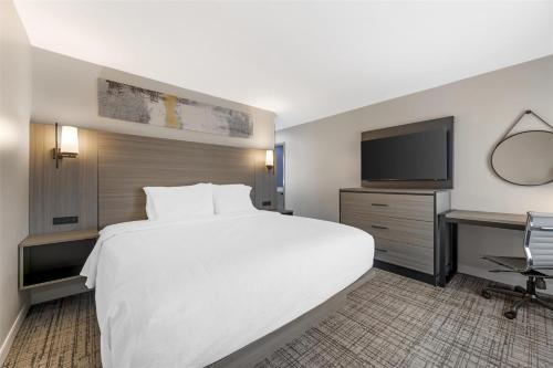 a hotel room with a large white bed and a desk at Best Western Plus Elgin - Chicago in West Dundee