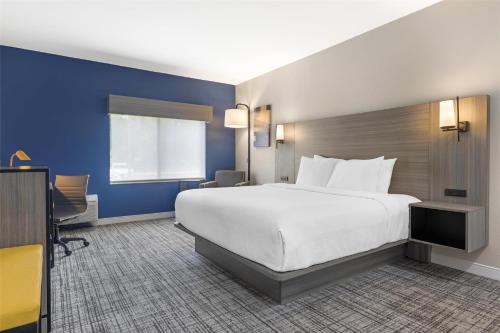 a hotel room with a large bed and blue walls at Best Western Plus Elgin - Chicago in West Dundee