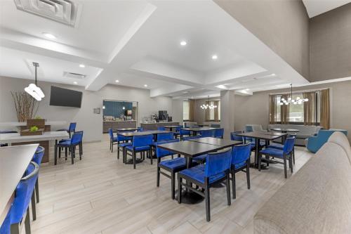 a dining room with tables and blue chairs at Best Western Plus Elgin - Chicago in West Dundee