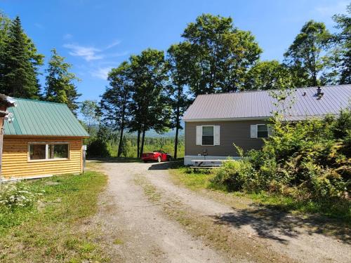 a dirt road next to a house and a car at Belvidere Mountain Vista Home by Stowe Jay Peak Smuggs Long Trail in Belvidere Center