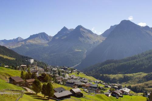 a village on a hill with mountains in the background at Rothornblick 52 by Arosa Vacations, Wohnung mit Bergblick und Privatparkplatz in Arosa