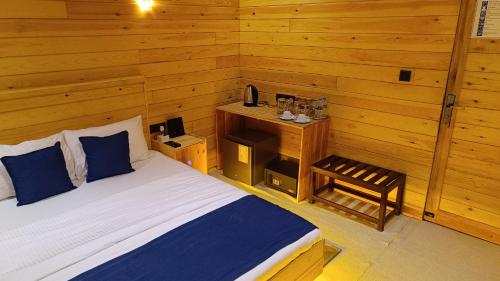 a bedroom with a bed and a wooden wall at Wood Chalets Ella in Ella