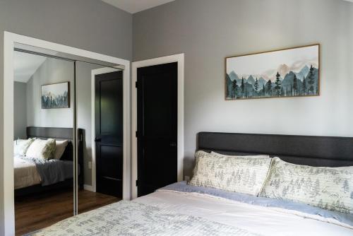 a bedroom with a bed and a mirror at NEW Skye Ridge Carriage House with Hot Tub in Killington