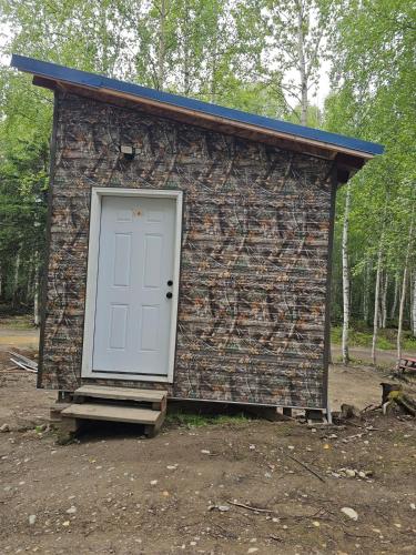 a small brick building with a white door at Camo Cabin #4 in Houston