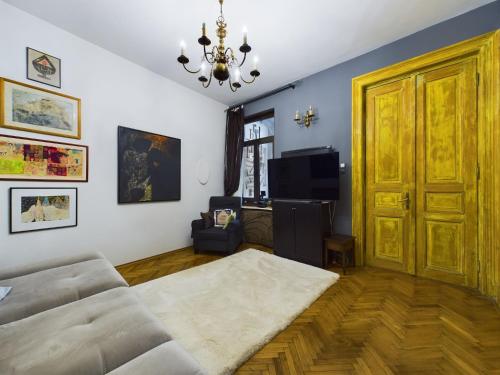 a living room with a couch and a chandelier at Art Villa Bucharest in Bucharest