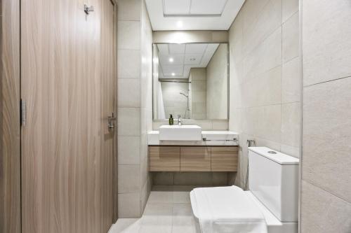 une salle de bain avec toilettes, lavabo et miroir dans l'établissement Elite Escape - Getaway in Azizi Riviera 26, à Dubaï