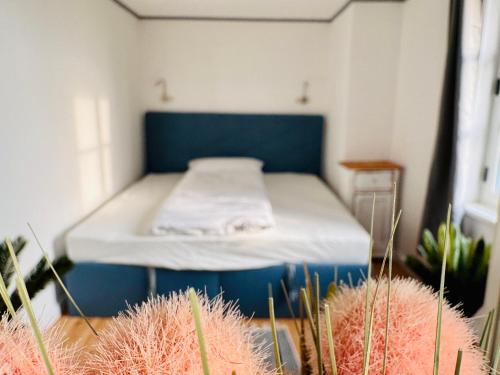 a small room with a bed with a blue headboard at Eiszeit in Bitterfeld