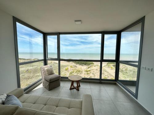 a living room with a couch and a view of the ocean at Departamento de lujo con vista al mar in Monte Hermoso