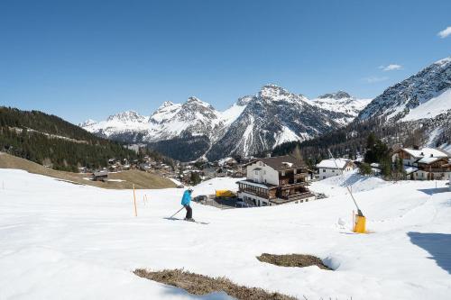 a person on skis in the snow with mountains at Höfi Studio by Arosa Vacations, Direkt vor den Skiliften Arosa-Hörnli in Arosa