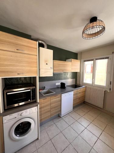 a kitchen with a washer and a washing machine at Le Pasteur - Cosy and Central in Roanne