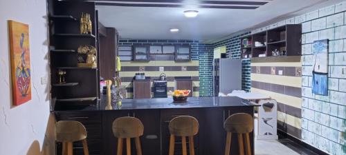 una cocina con encimera negra y taburetes en WATO Villas, en Bulindo