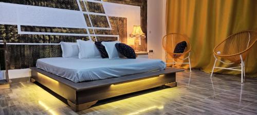 Un dormitorio con una cama y dos sillas. en WATO Villas, en Bulindo