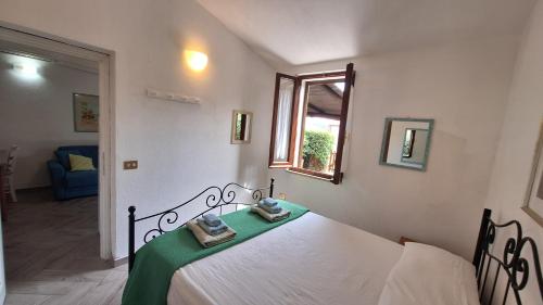 Un dormitorio con una cama con dos toallas encima. en Casa di Lu' - Bilocale con giardino - Porto Pollo, en Porto Pollo