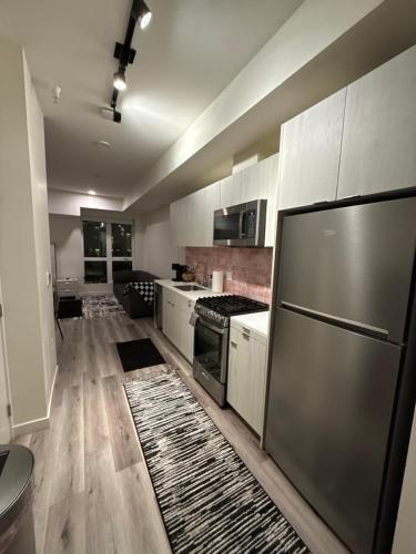 a kitchen with stainless steel appliances and wooden floors at Luxury Walk of Fame Studio in Los Angeles