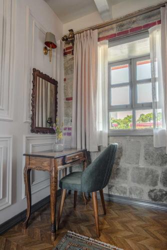 a desk and a chair in a room with a window at Orion Adatepe in Adatepe