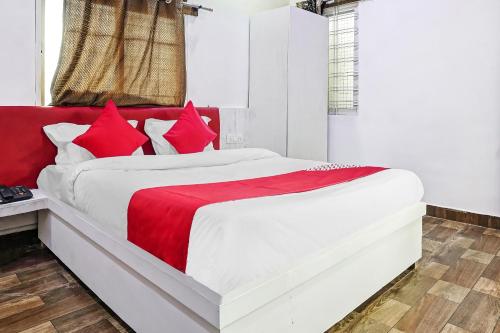 a red and white bed in a white room at Hotel O CeeRock in Bhopal