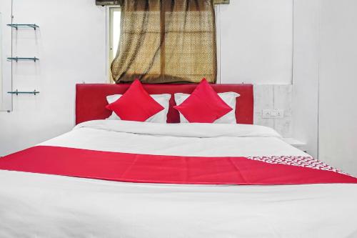 a red and white bed with red pillows on it at Hotel O CeeRock in Bhopal