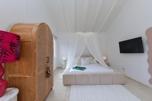 a bedroom with a bed with a canopy at Moderne Studio Sea dichtbij de zee met zwembad in Oranjestad