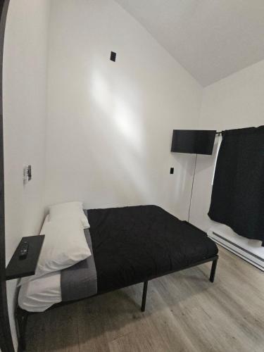 a bedroom with a bed with a black blanket and a lamp at Cabin Number 6 in Houston