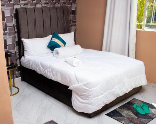 a bed with white sheets and towels on it at ebc lodge in Ndola