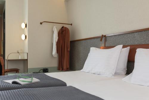 a hotel room with a bed with a book on it at Evripides Hotel in Athens