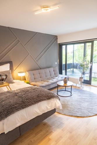 a bedroom with a large bed and a couch at Stilvolles Apartment in Siegen in Siegen