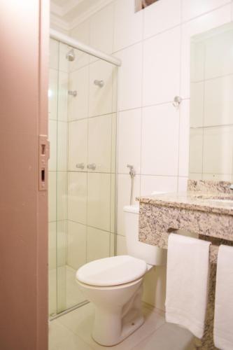 a bathroom with a toilet and a glass shower at Hotel Dan Inn Express Ribeirão Preto By Nacional Inn in Ribeirão Preto
