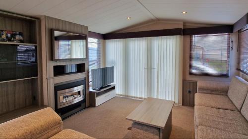 a living room with a couch and a fireplace at Megerlilly Family Hideaway, Church Farm in Pagham