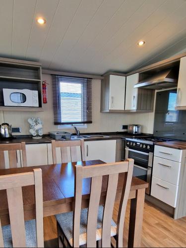 a kitchen with a table and chairs in a kitchen at Megerlilly Family Hideaway, Church Farm in Pagham