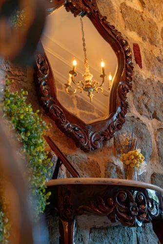 a mirror on a stone wall with a chandelier at Orion Adatepe in Adatepe