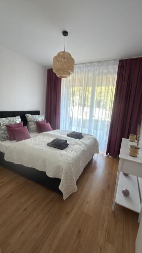 a bedroom with a large bed with purple curtains at Corale in Łagów