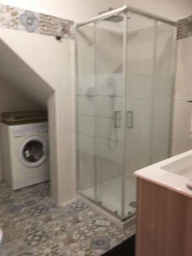 a glass shower in a bathroom with a washing machine at casa vacanza serena in Palazzago